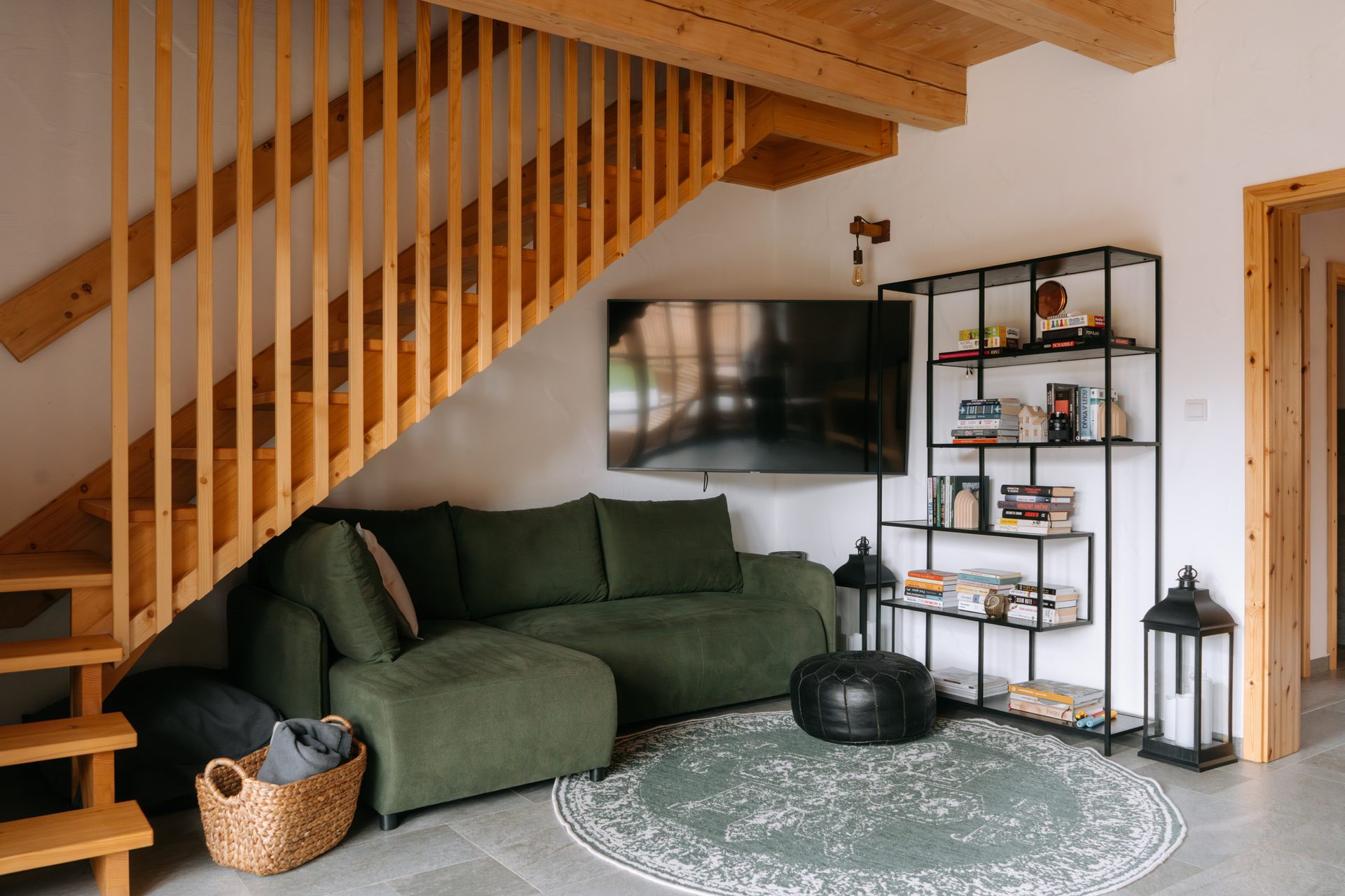 Living room with library and large sofa in Apartment 2 of Výtoň 263 cottage